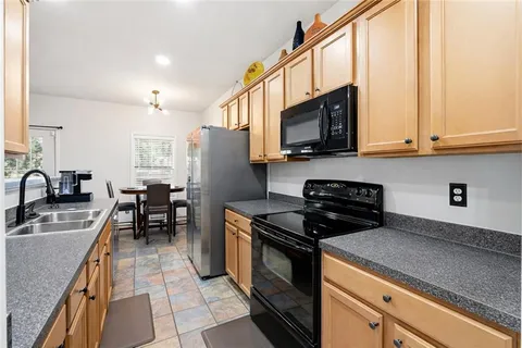 a kitchen with stainless steel appliances granite countertop a stove a sink and a microwave
