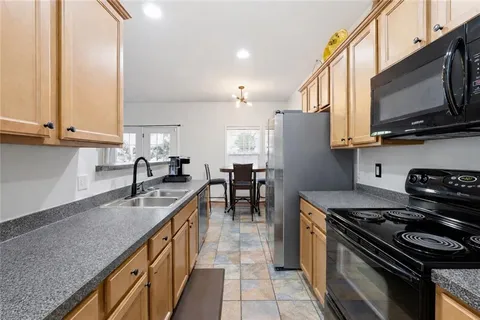 a kitchen with stainless steel appliances granite countertop a stove a sink and a microwave