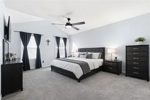 a spacious bedroom with a bed and a chandelier