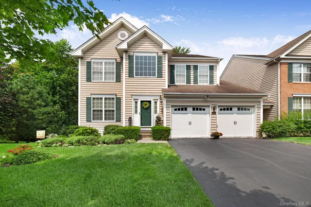 a front view of a house with a yard and trees