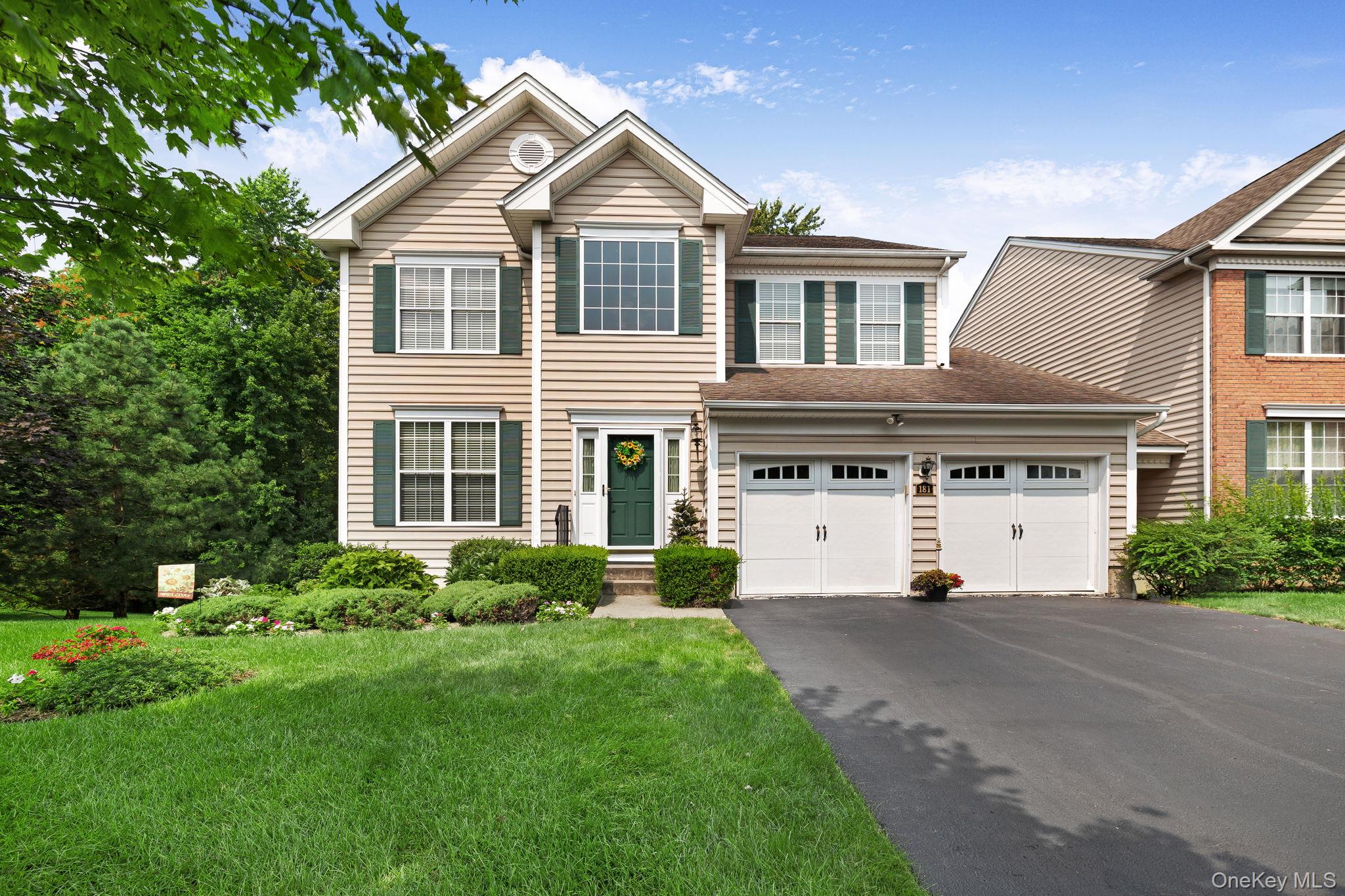 a front view of a house with a yard and trees
