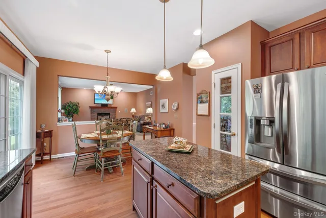 a kitchen with stainless steel appliances granite countertop a refrigerator a stove and a wooden floors