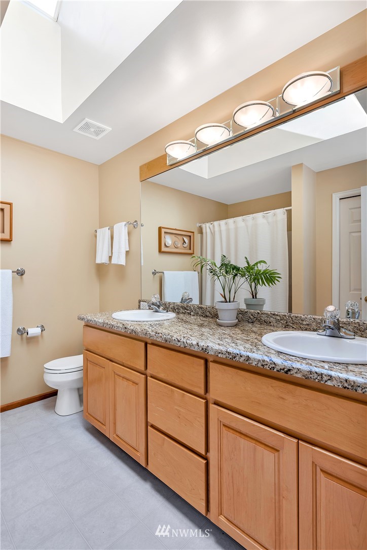4916 177th Place Southeast Bothell, WA 98012 - Photo 21 of 25 a bathroom with a granite countertop sink and a mirror
