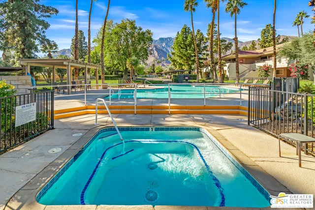 a view of a swimming pool with a yard and plants