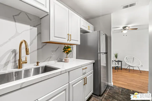 a kitchen with stainless steel appliances granite countertop a refrigerator and a sink