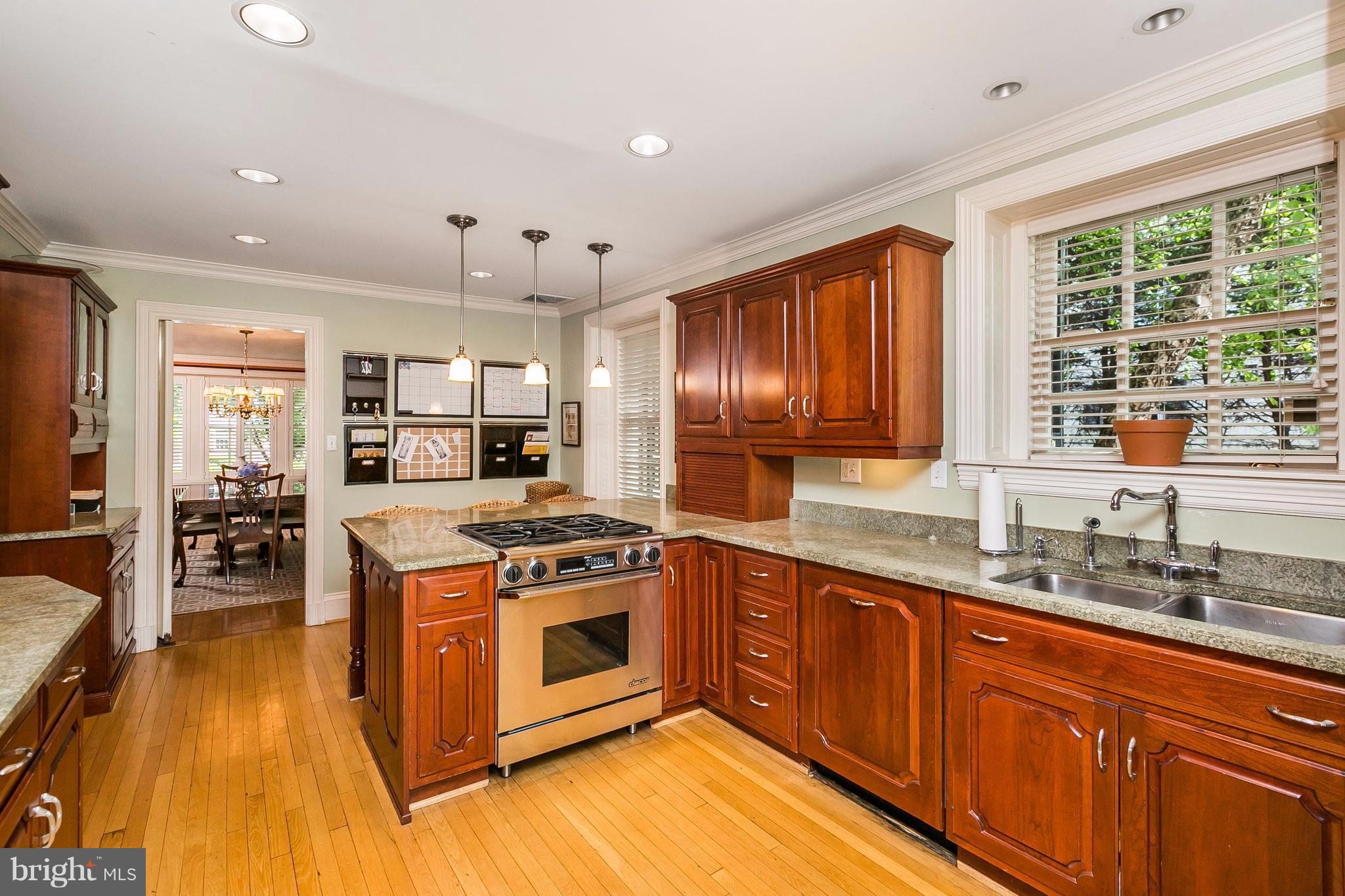 6306 Blenheim Road Baltimore, MD 21212 - Photo 11 of 30 a kitchen with stainless steel appliances granite countertop a stove a sink dishwasher a refrigerator and cabinets with wooden floor