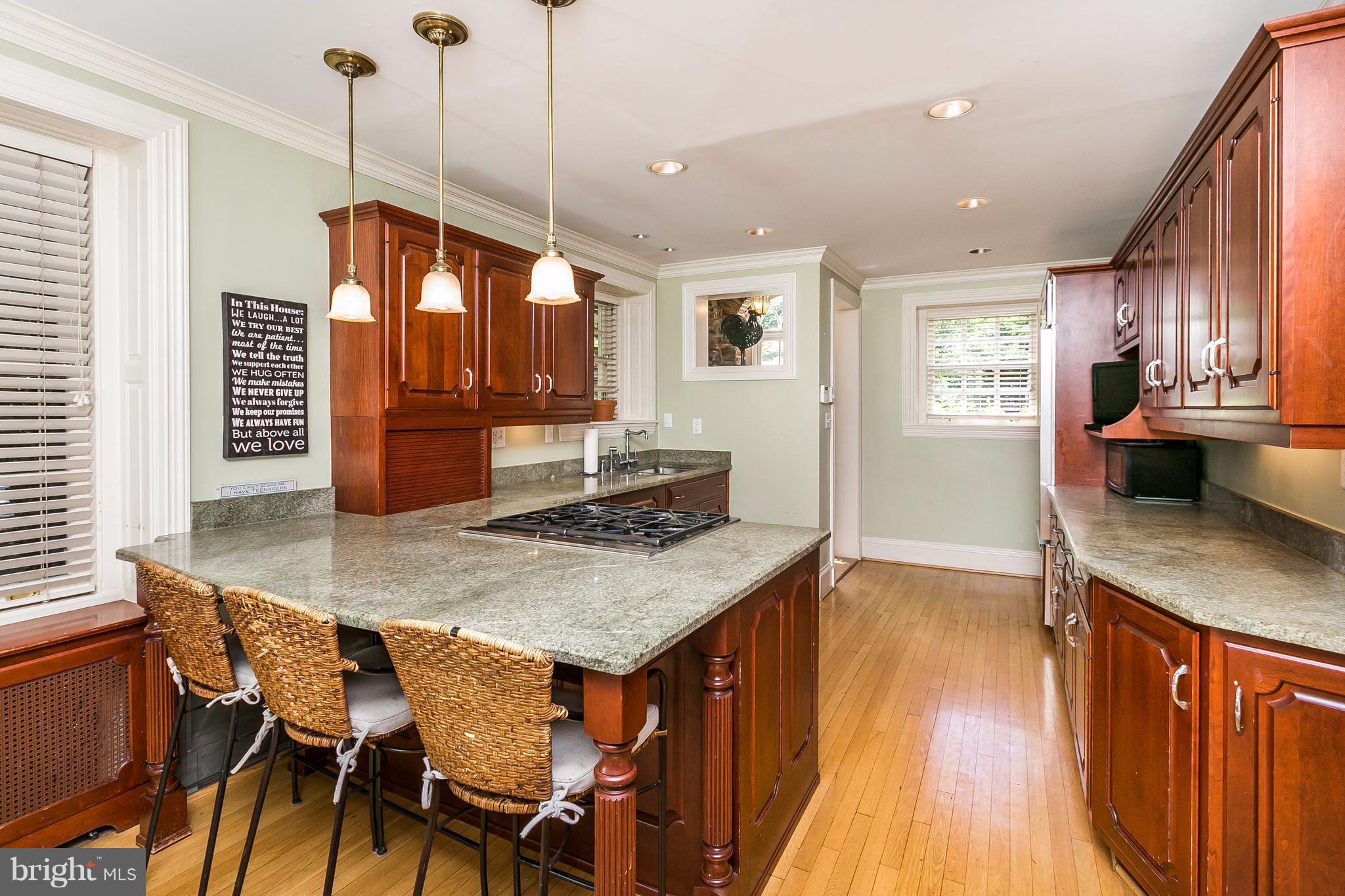 6306 Blenheim Road Baltimore, MD 21212 - Photo 12 of 30 a kitchen with stainless steel appliances granite countertop a stove a refrigerator a sink a dining table and chairs with wooden floor