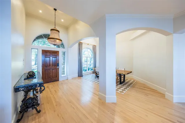 a view of a hallway with wooden floor and a living room