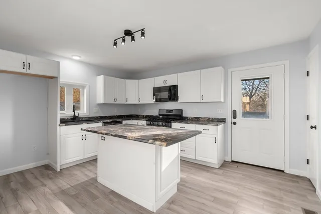 a kitchen with stainless steel appliances granite countertop a stove a sink dishwasher and a refrigerator