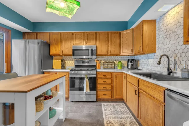 a kitchen with stainless steel appliances a sink and a refrigerator
