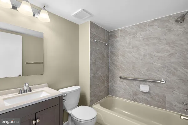 a bath tub sitting next to a white sink and toilet
