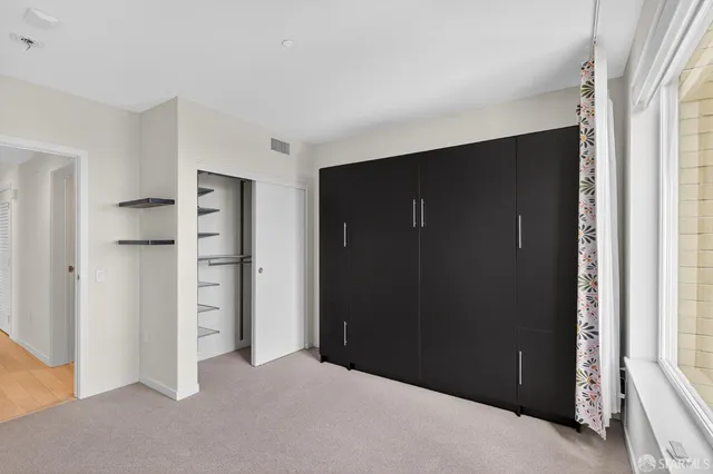 an empty room with closet and wooden floor