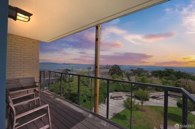 a front view of a building with garden and trees