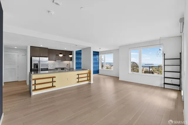a view of an empty room with window and wooden floor