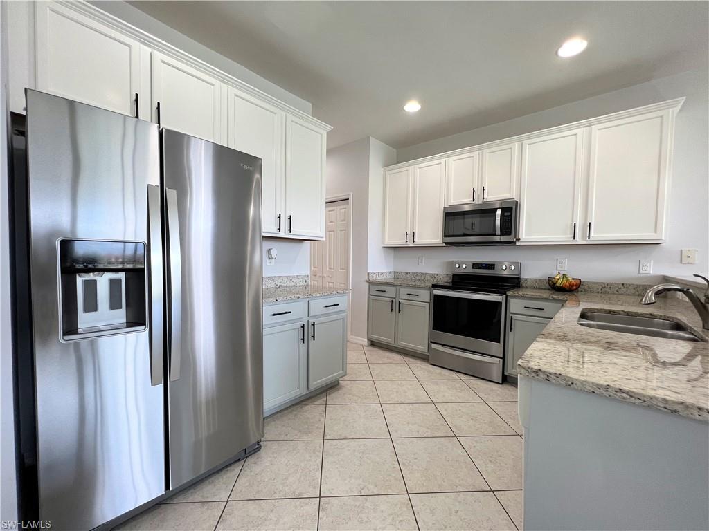 14776 Sutherland Avenue, Unit 416 Naples, FL 34119 - Photo 15 of 50 a kitchen with stainless steel appliances granite countertop a refrigerator sink and stove