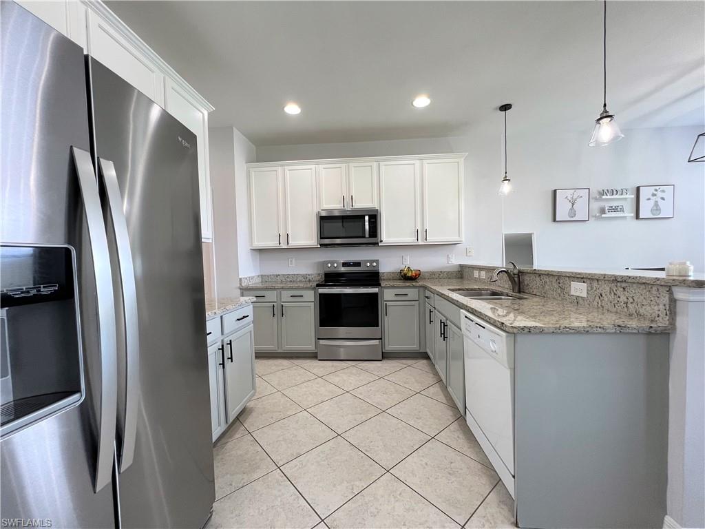 14776 Sutherland Avenue, Unit 416 Naples, FL 34119 - Photo 16 of 50 a kitchen with granite countertop a refrigerator and a sink