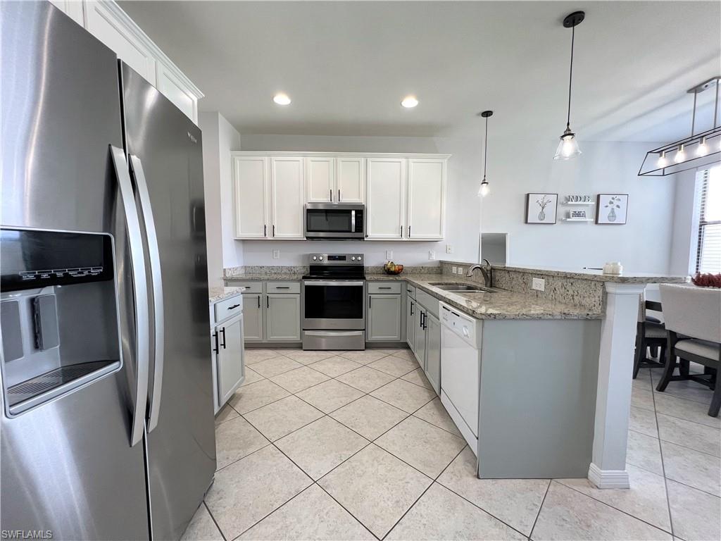 14776 Sutherland Avenue, Unit 416 Naples, FL 34119 - Photo 17 of 50 a kitchen with stainless steel appliances granite countertop a refrigerator a stove a sink and a microwave