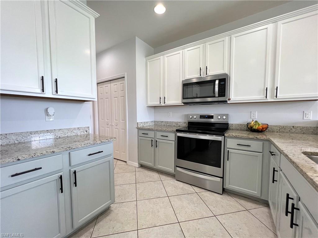 14776 Sutherland Avenue, Unit 416 Naples, FL 34119 - Photo 18 of 50 a kitchen with cabinets stainless steel appliances and a sink