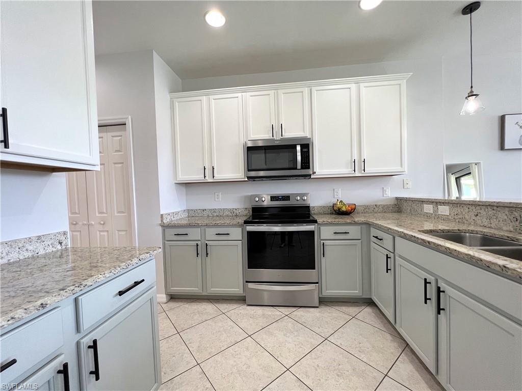 14776 Sutherland Avenue, Unit 416 Naples, FL 34119 - Photo 19 of 50 a kitchen with granite countertop white cabinets appliances and a sink