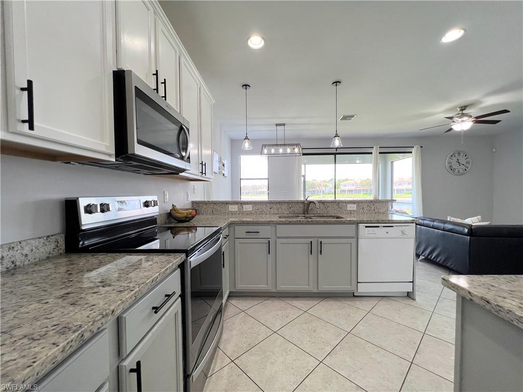 14776 Sutherland Avenue, Unit 416 Naples, FL 34119 - Photo 20 of 50 a kitchen with stainless steel appliances granite countertop a sink and stove top oven