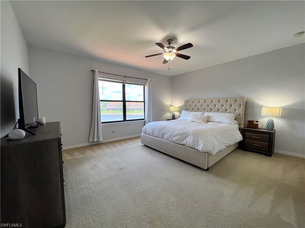 14776 Sutherland Avenue, Unit 416 Naples, FL 34119 - Photo 25 of 50 a spacious bedroom with a bed and a flat screen tv