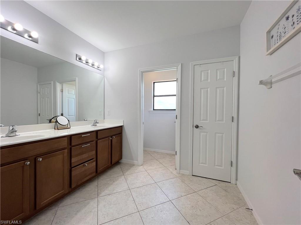 14776 Sutherland Avenue, Unit 416 Naples, FL 34119 - Photo 28 of 50 a spacious bathroom with a double vanity sink a mirror and a