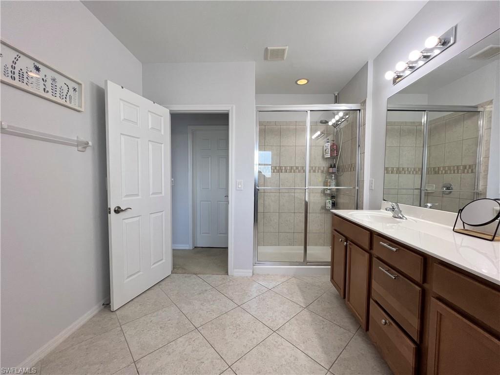 14776 Sutherland Avenue, Unit 416 Naples, FL 34119 - Photo 30 of 50 a spacious bathroom with a shower sink and mirror