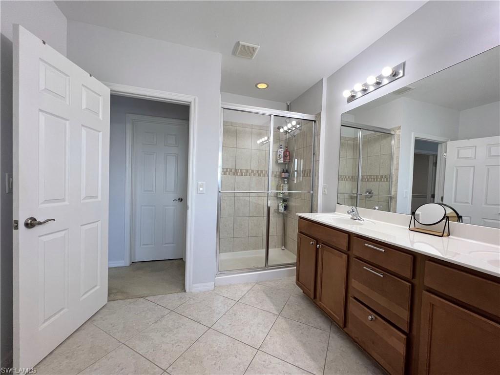 14776 Sutherland Avenue, Unit 416 Naples, FL 34119 - Photo 31 of 50 a bathroom with a granite countertop sink mirror and shower
