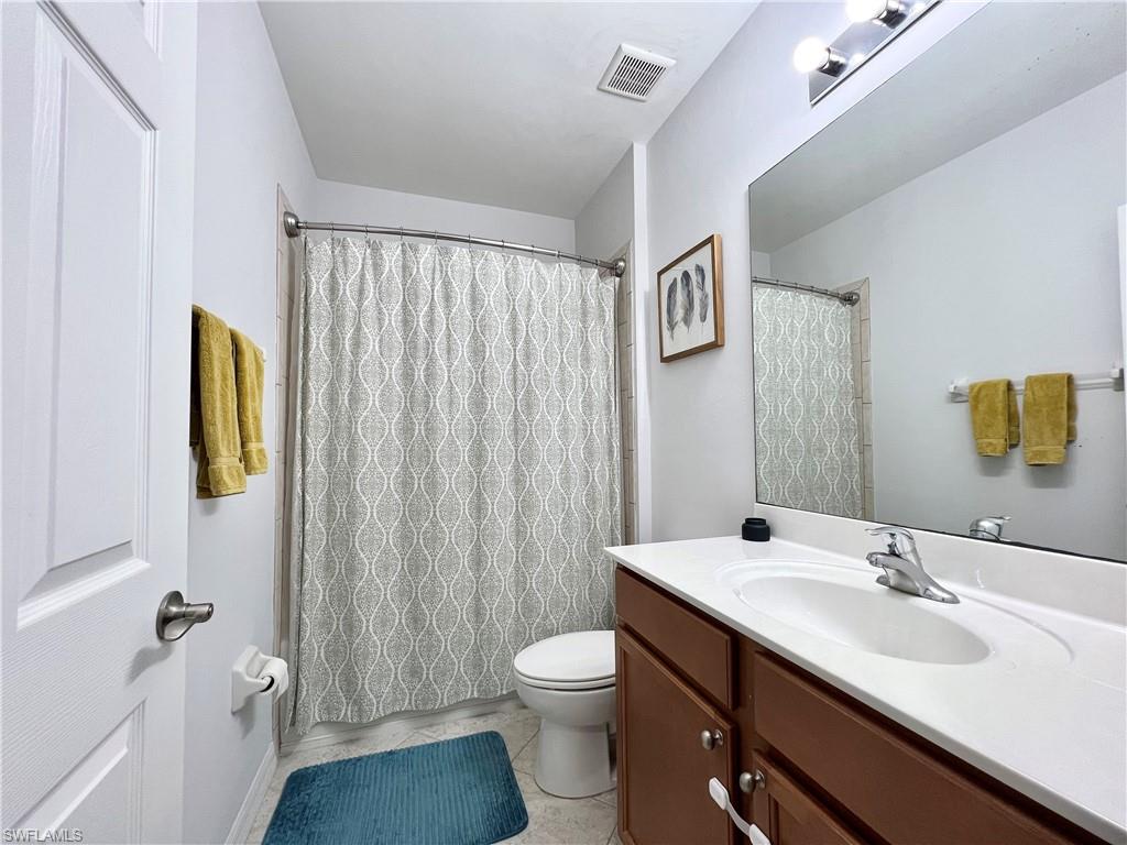 14776 Sutherland Avenue, Unit 416 Naples, FL 34119 - Photo 43 of 50 a bathroom with a toilet a sink and a mirror