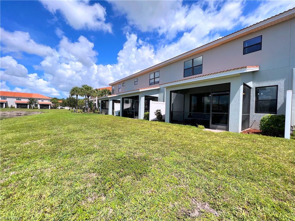 14776 Sutherland Avenue, Unit 416 Naples, FL 34119 - Photo 48 of 50 front view of a brick house with a yard