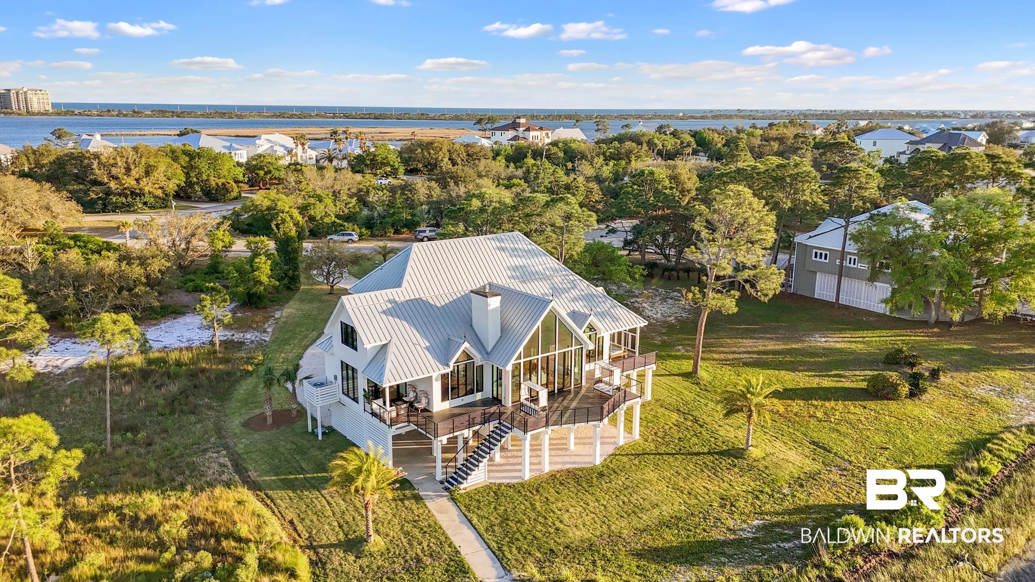 33349 River Road Orange Beach, AL 36561 - Photo 42 of 61 White coastal-style residence featuring a metal roof and extensive fenestration