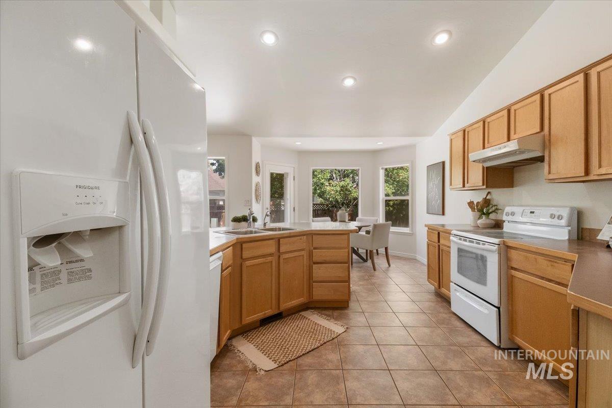 2032 Talus Loop Twin Falls, ID 83301 - Photo 19 of 43 Bright kitchen with warm wood cabinetry, light countertops, and tile flooring