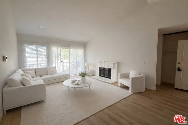 a living room with fireplace furniture and wooden floor