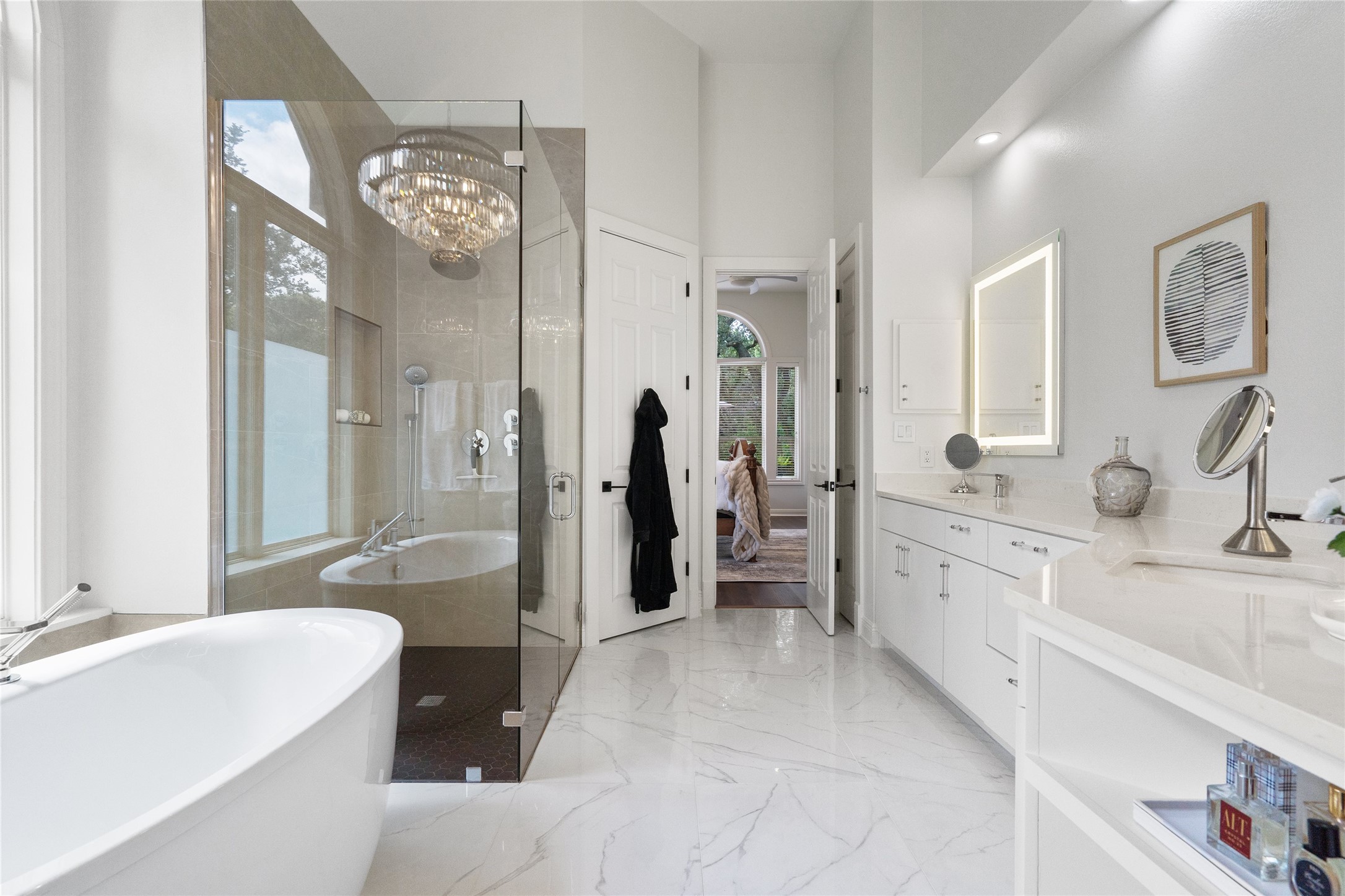 4313 Rio Robles Drive Austin, TX 78746 - Photo 23 of 40 A well-lit primary bathroom showcases a glass-enclosed shower, a separate soaking tub, and a double vanity.