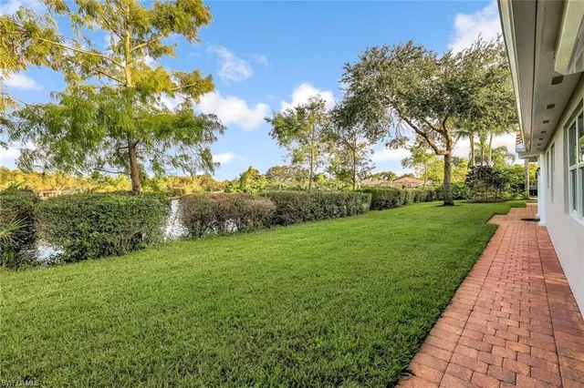 a large white kitchen with kitchen island a sink a counter top stainless steel appliances and cabinets