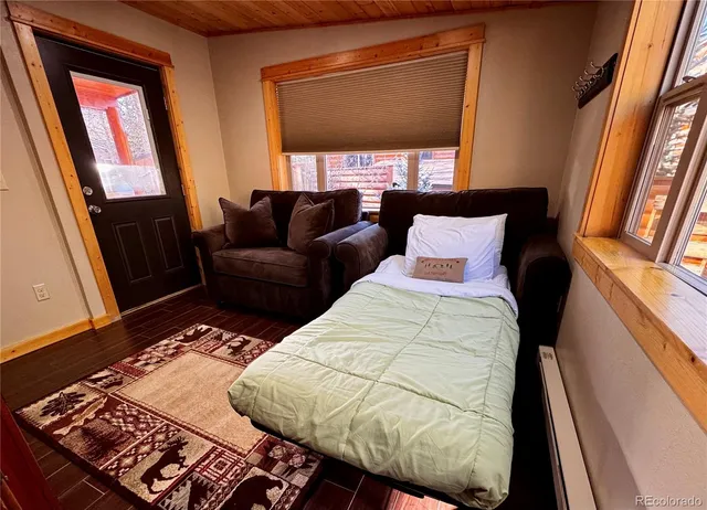 a kitchen with stainless steel appliances granite countertop a stove a refrigerator a kitchen island a dining table and chairs with wooden floor