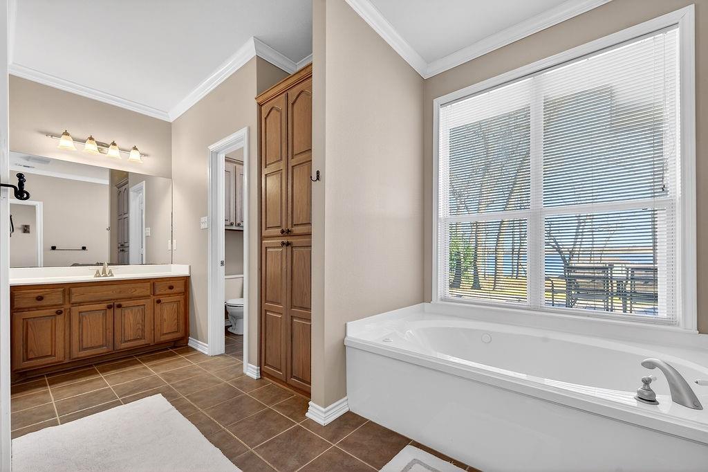7811 Double Oaks Road Athens, TX 75752 - Photo 16 of 38 a spacious bathroom with a tub sink and mirror