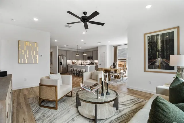 a living room with furniture and a wooden floor