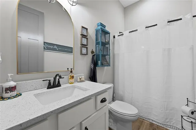 a bathroom with a granite countertop sink toilet and shower