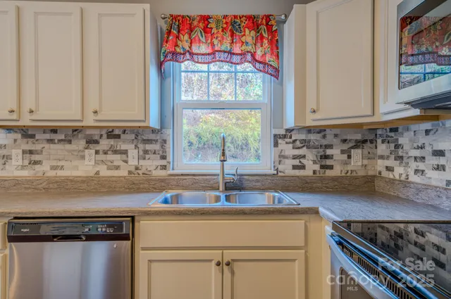 a kitchen with stainless steel appliances a sink stove and cabinets