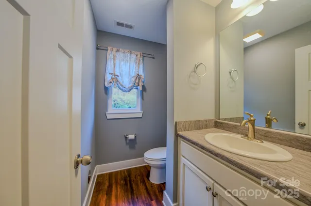 a bathroom with a granite countertop sink toilet and a mirror
