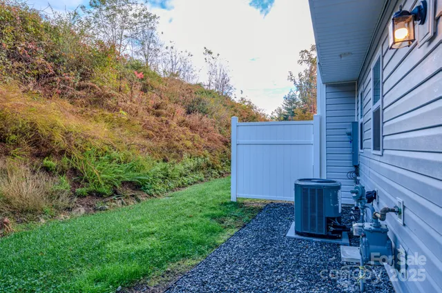 a view of a backyard with plants and brick wall