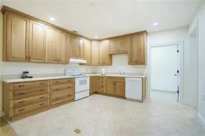 a kitchen with granite countertop a sink cabinets and stainless steel appliances