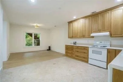 a kitchen with granite countertop white cabinets and white appliances