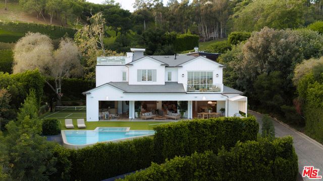 a aerial view of a house with swimming pool next to a yard