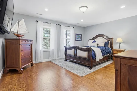 a spacious bedroom with a bed lamp closet and window