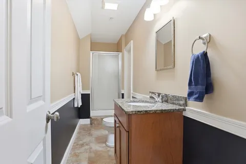 a en suite bathroom with a granite countertop sink and a mirror