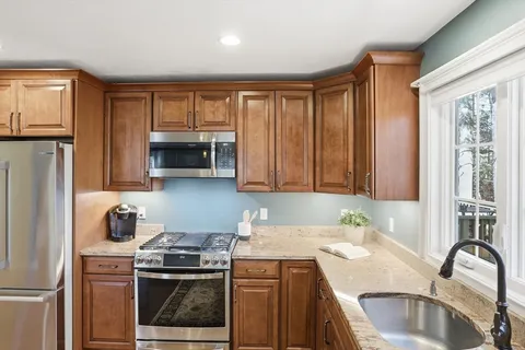 a kitchen with granite countertop a sink stove and refrigerator