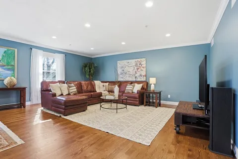 a living room with furniture and a wooden floor