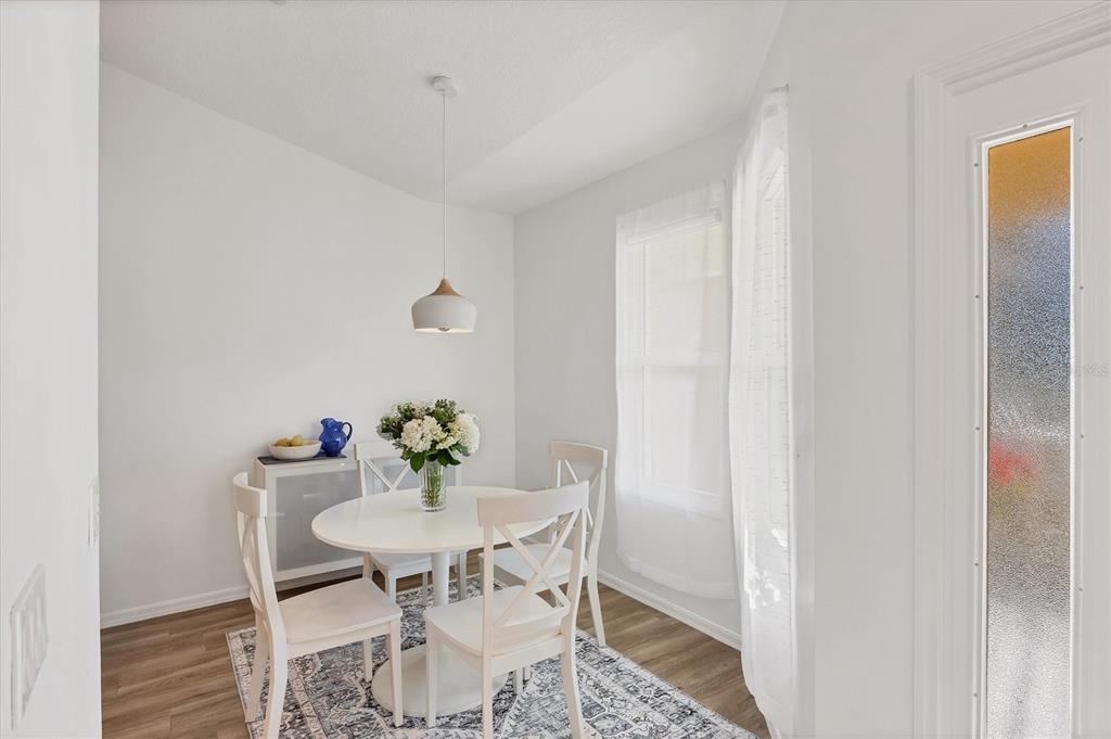 7131 Boca Grove Place, Unit 203 Lakewood Ranch, FL 34202 - Photo 13 of 50 a view of a dining room with furniture and wooden floor